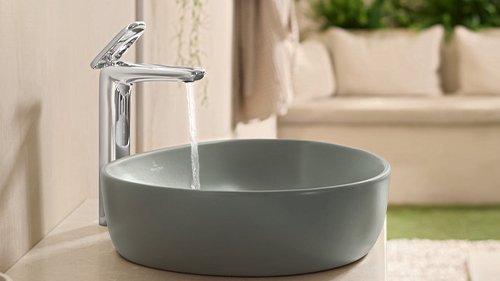 Ein grünes Waschbecken in dem das Wasser laeuft