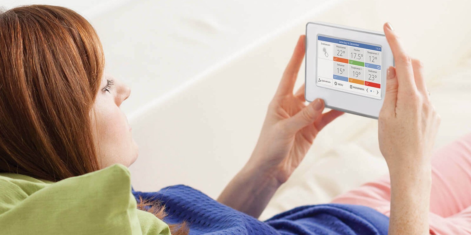 Eine Frau die ein Digitalregler in den Haenden haelt